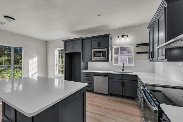 a kitchen with stainless steel appliances granite countertop a sink counter space and cabinets