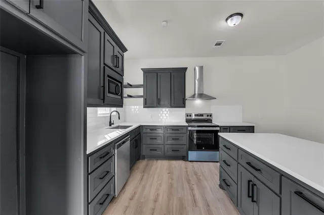 a kitchen with stainless steel appliances granite countertop hardwood a stove and cabinets