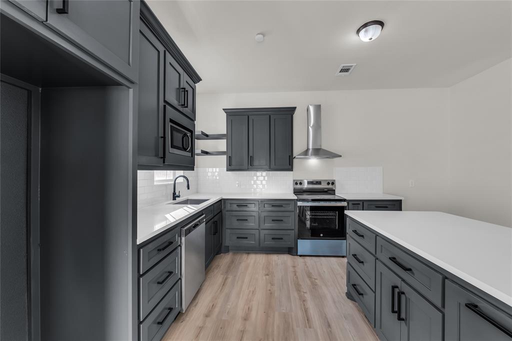 2524 McFerrin Avenue Waco, TX 76708 - Photo 10 of 29 a kitchen with stainless steel appliances granite countertop hardwood a stove and cabinets