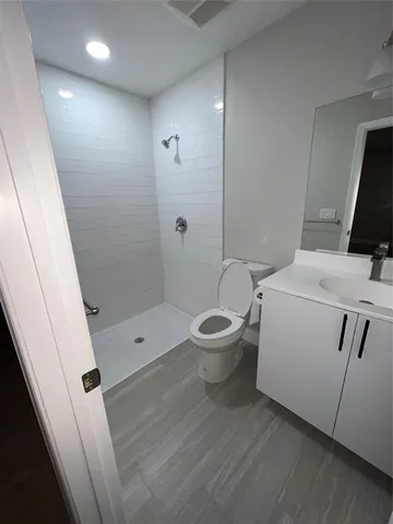 a bathroom with a sink a toilet a mirror and shower