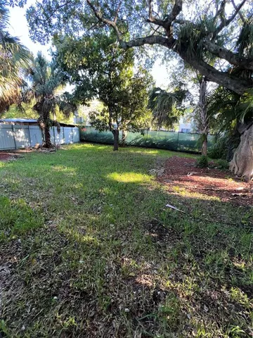 a view of a backyard with plants and wooden fence