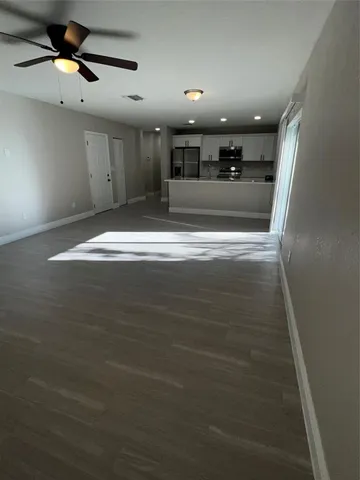 a kitchen with kitchen island a sink a stove wooden floor and black cabinets