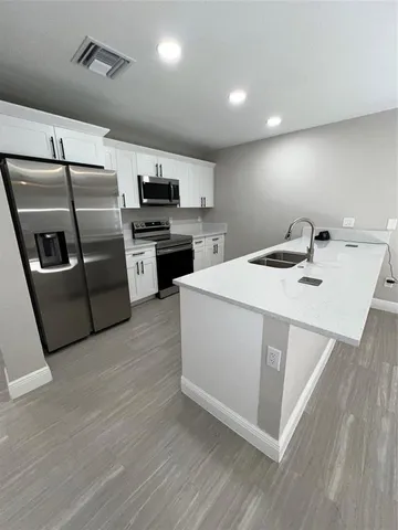 a kitchen with stainless steel appliances a sink dishwasher stove top oven and refrigerator
