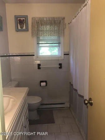 a bathroom with a toilet a sink and a window