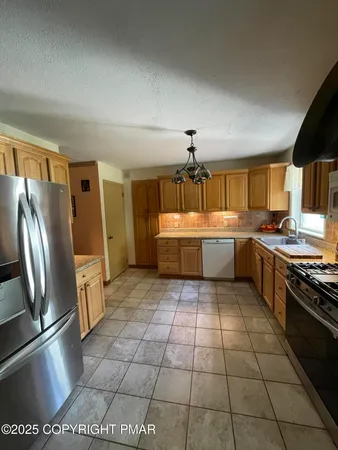 a large kitchen with cabinets and stainless steel appliances