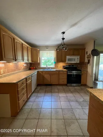 a kitchen with stainless steel appliances granite countertop a stove a sink dishwasher and a refrigerator