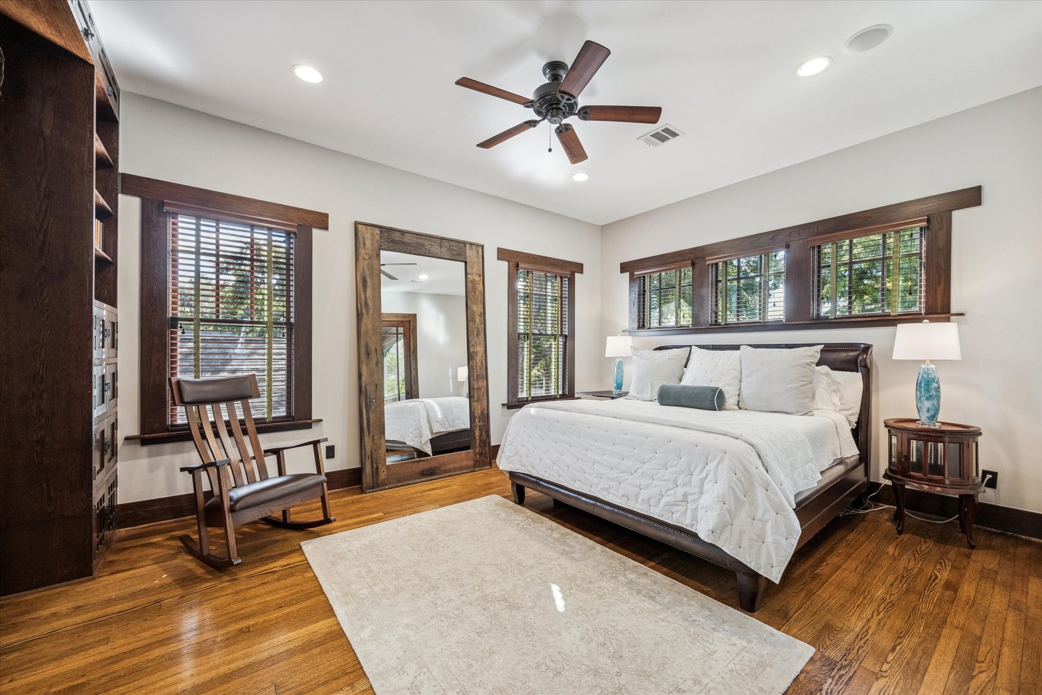 512 Archer Street Houston, TX 77009 - Photo 21 of 40 Spacious primary suite with hardwood floors, recessed lighting, abundant windows showcasing treetop views, and access to the screened-in porch.