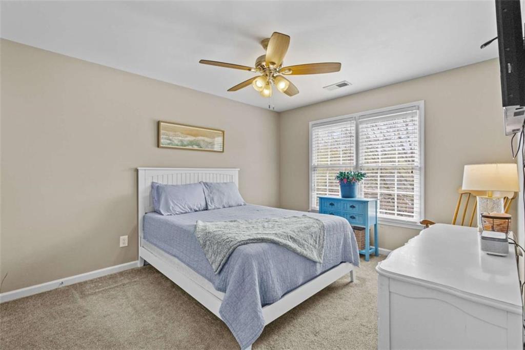 1148 Maple Creek Ridge Loganville, GA 30052 - Photo 22 of 46 a bedroom with a bed and a chandelier
