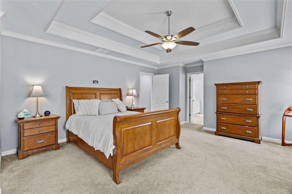 1148 Maple Creek Ridge Loganville, GA 30052 - Photo 29 of 46 a bedroom with a bed and a chandelier