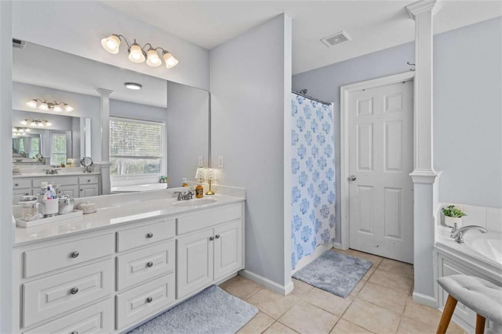 1148 Maple Creek Ridge Loganville, GA 30052 - Photo 32 of 46 a bathroom with a granite countertop sink a toilet a shower and a mirror