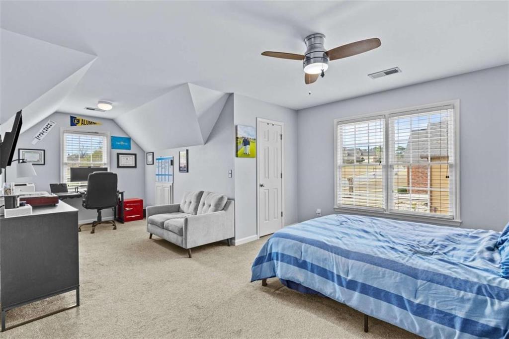 1148 Maple Creek Ridge Loganville, GA 30052 - Photo 34 of 46 a bedroom with a bed a couch and a window