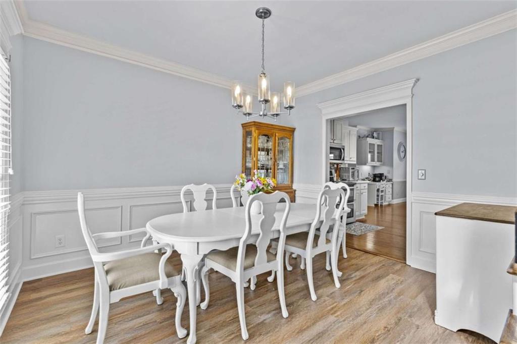 1148 Maple Creek Ridge Loganville, GA 30052 - Photo 7 of 46 a view of a dining room with furniture wooden floor and chandelier