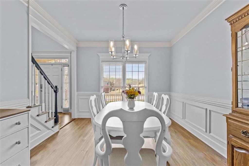 1148 Maple Creek Ridge Loganville, GA 30052 - Photo 8 of 46 a dining room with furniture a chandelier and wooden floor