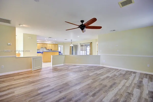a view of an empty room with a window and wooden floor