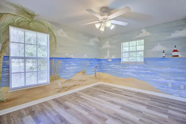 an empty room with wooden floor and window