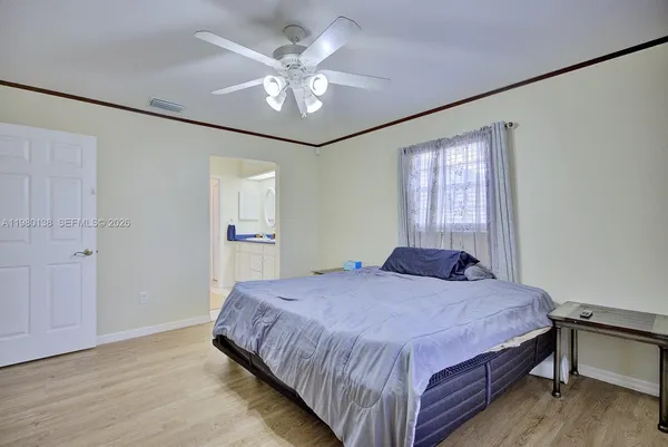 a bedroom with a large bed chandelier and a window