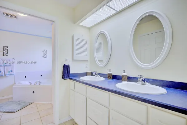 a bathroom with a granite countertop sink a mirror and a shower