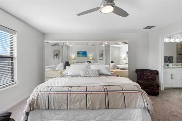 a large bedroom with a bed and lamp