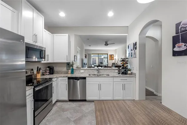 a kitchen with stainless steel appliances granite countertop a stove a sink dishwasher and a refrigerator