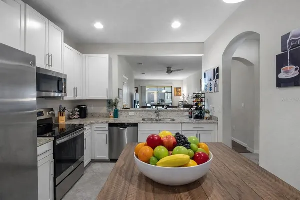 a kitchen with stainless steel appliances granite countertop a sink a stove and cabinets