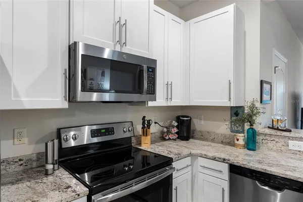 a kitchen with stainless steel appliances kitchen island a table and chairs in it