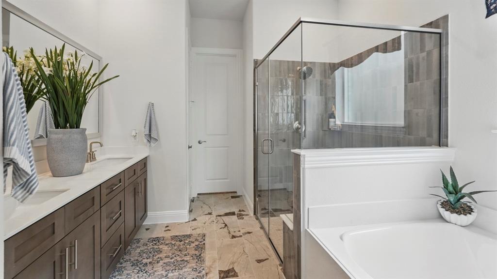 1016 Pitchfork Road Royse City, TX 75189 - Photo 12 of 35 a bathroom with a granite countertop sink a mirror a bathtub and shower