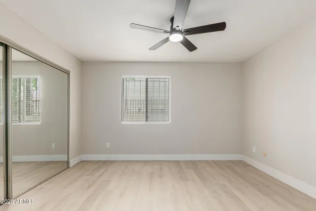 an empty room with a window and a fan