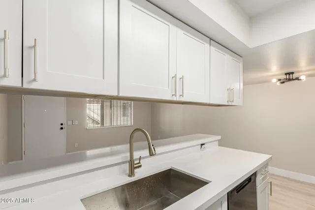 a kitchen with a sink cabinets and a window