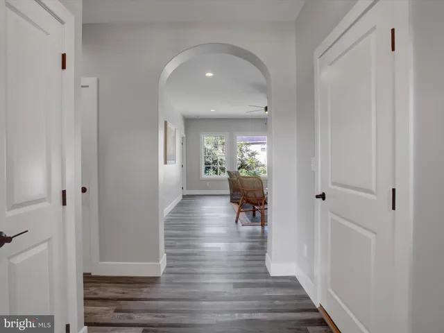 a hallway with wooden floor fireplace and living room