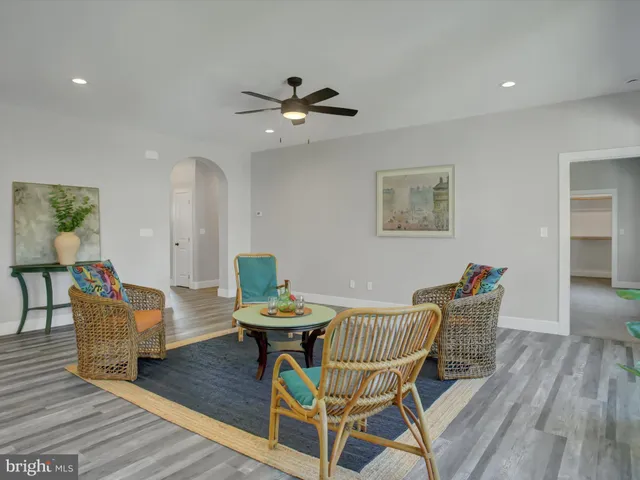 a living room with couches chairs and wooden floor