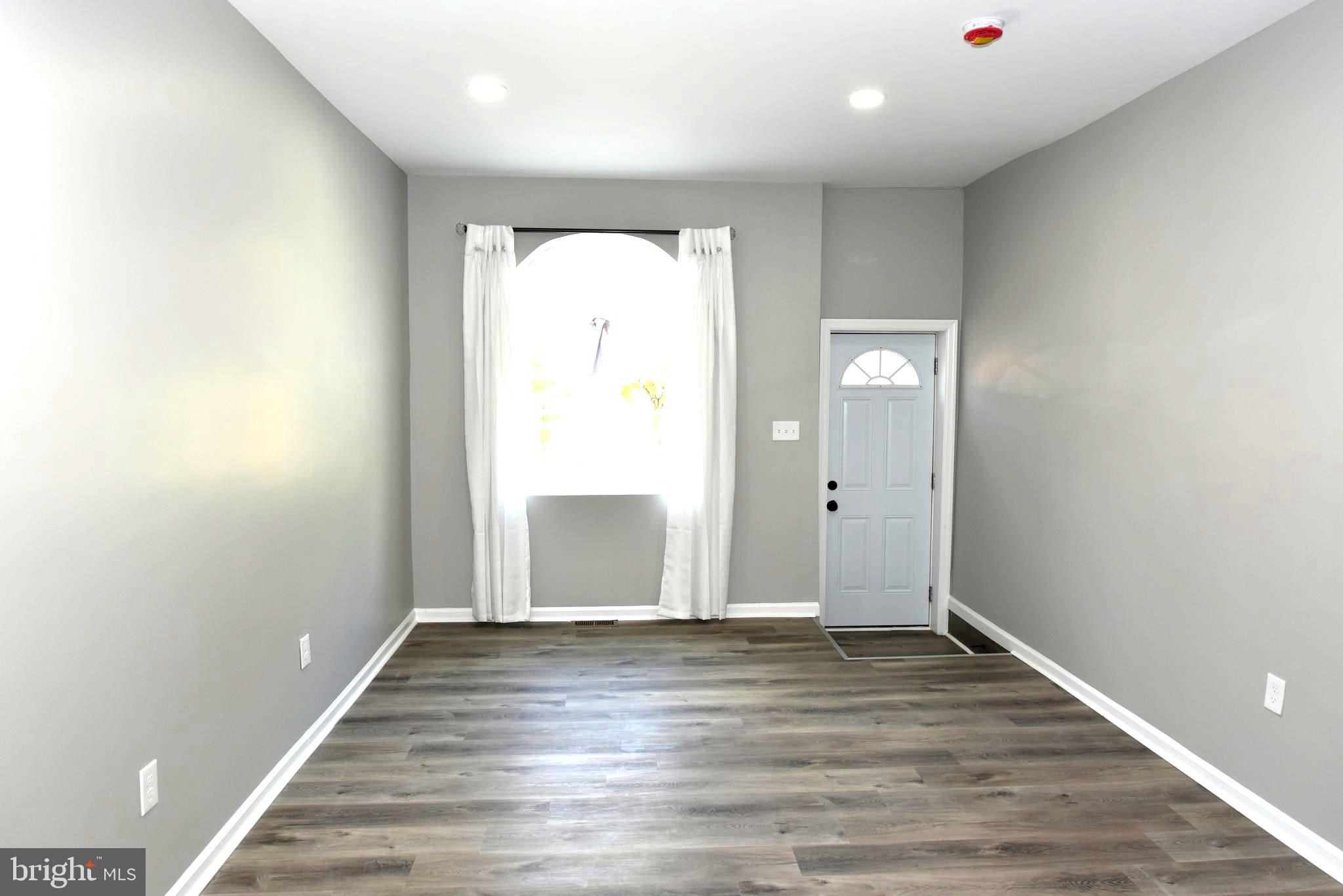 2225 West Baltimore Street Baltimore, MD 21223 - Photo 14 of 46 an empty room with wooden floor and windows