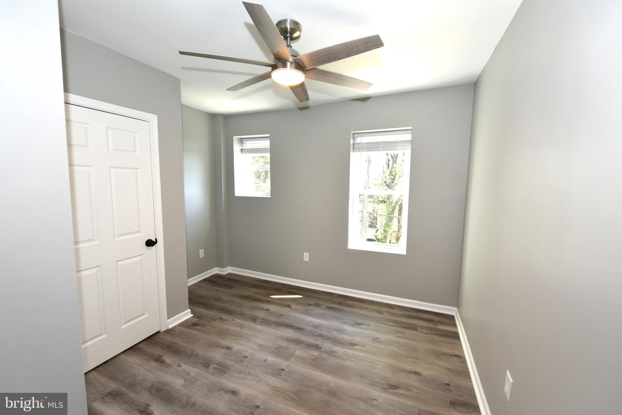 2225 West Baltimore Street Baltimore, MD 21223 - Photo 20 of 46 an empty room with wooden floor fan and windows