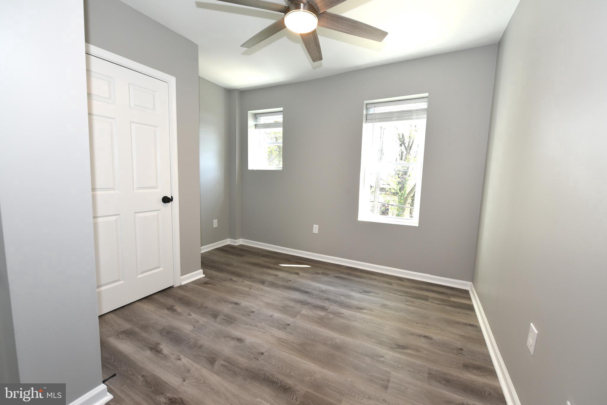 2225 West Baltimore Street Baltimore, MD 21223 - Photo 21 of 46 an empty room with wooden floor chandelier fan and windows