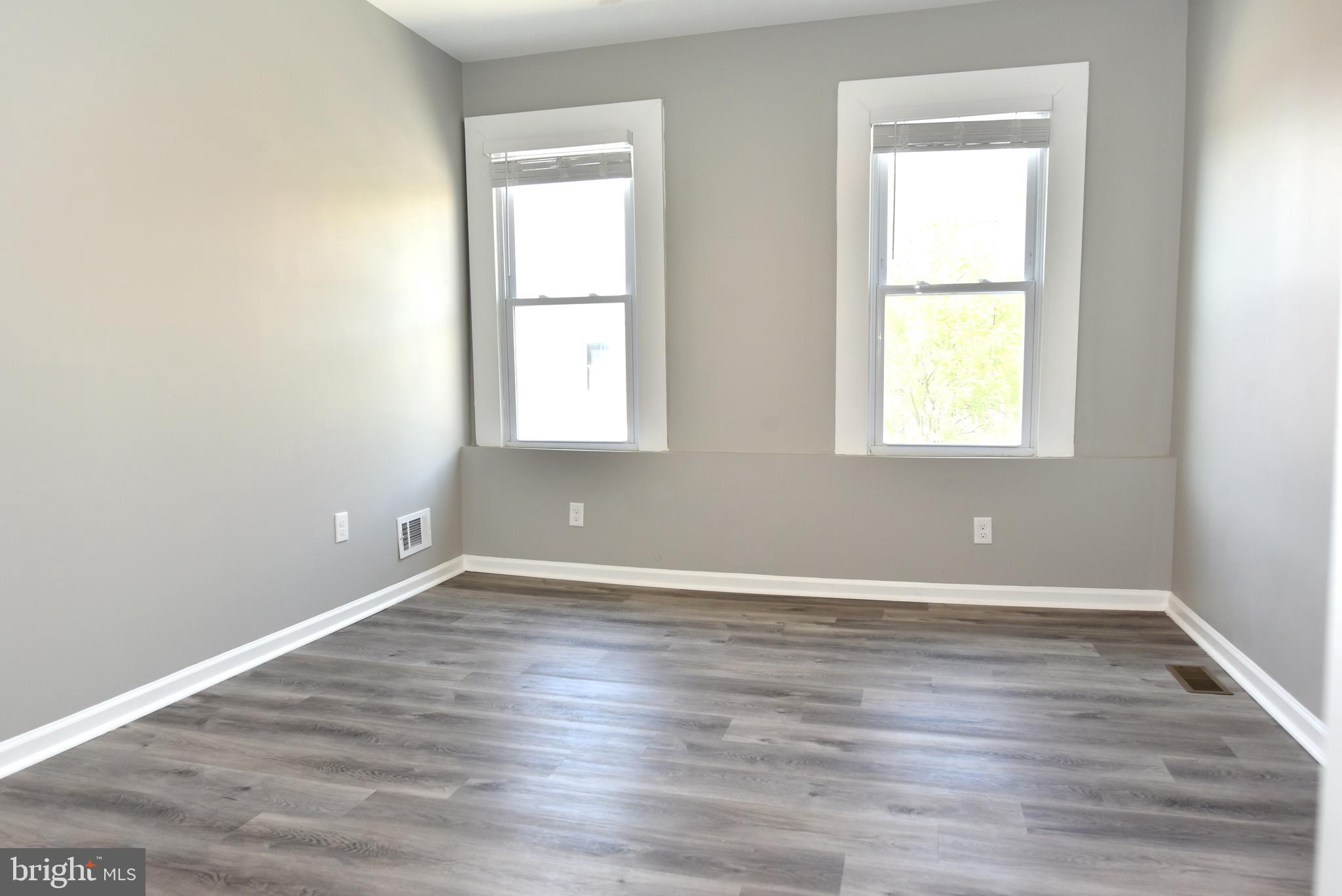 2225 West Baltimore Street Baltimore, MD 21223 - Photo 29 of 46 an empty room with wooden floor and windows