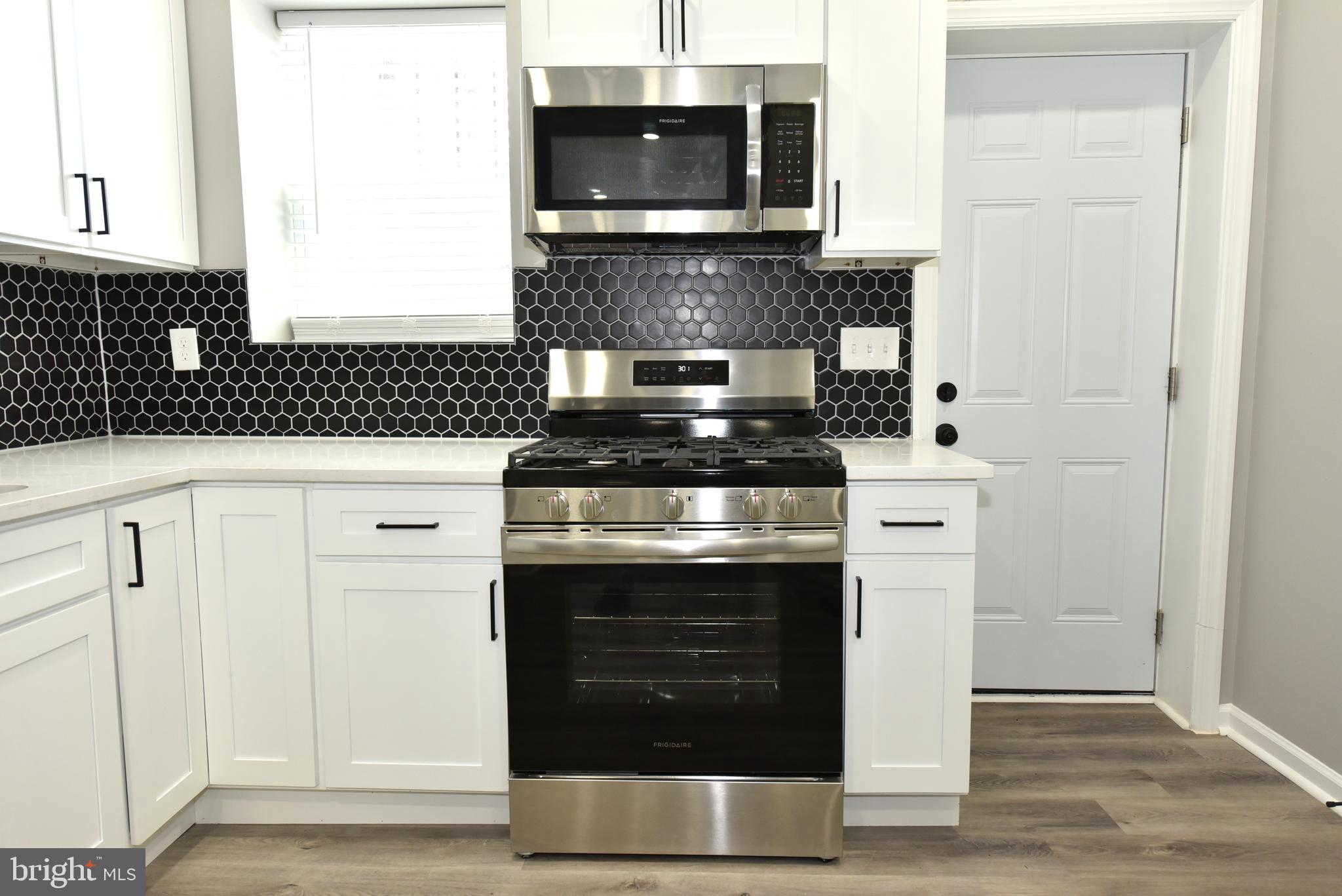 2225 West Baltimore Street Baltimore, MD 21223 - Photo 9 of 46 a kitchen with granite countertop white cabinets and stainless steel appliances