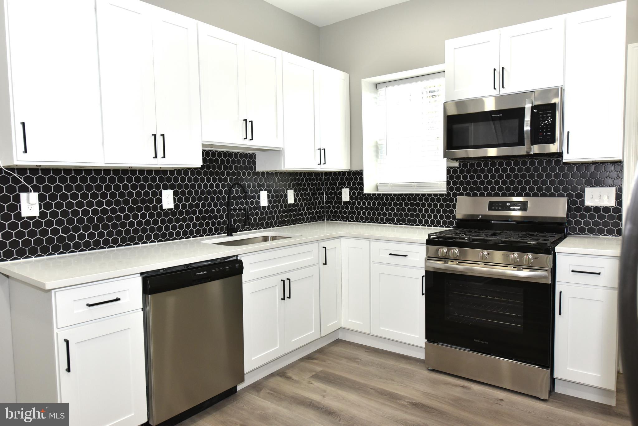 2225 West Baltimore Street Baltimore, MD 21223 - Photo 10 of 46 a kitchen with granite countertop a stove and a microwave
