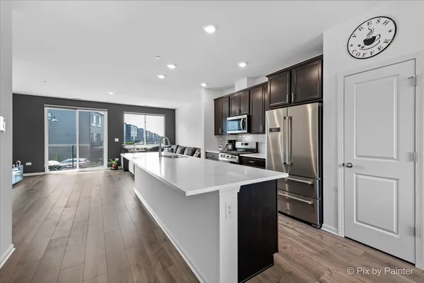a large kitchen with stainless steel appliances granite countertop a lot of counter space and wooden floor