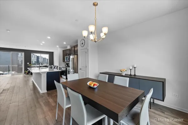 a view of a dining room with furniture a chandelier and wooden floor