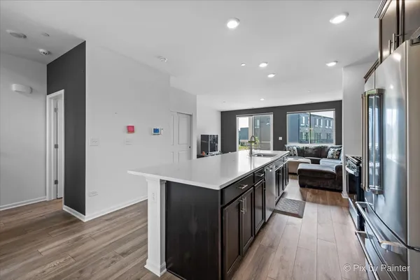 a kitchen with kitchen island granite countertop a sink appliances and wooden floor