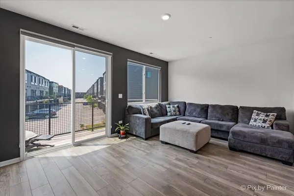 a living room with furniture and a floor to ceiling window