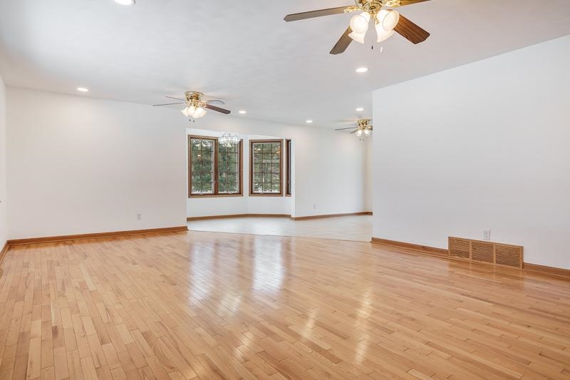 8611 Huber Road Belvidere, IL 61008 - Photo 29 of 79 an empty room with wooden floor chandelier fan and windows