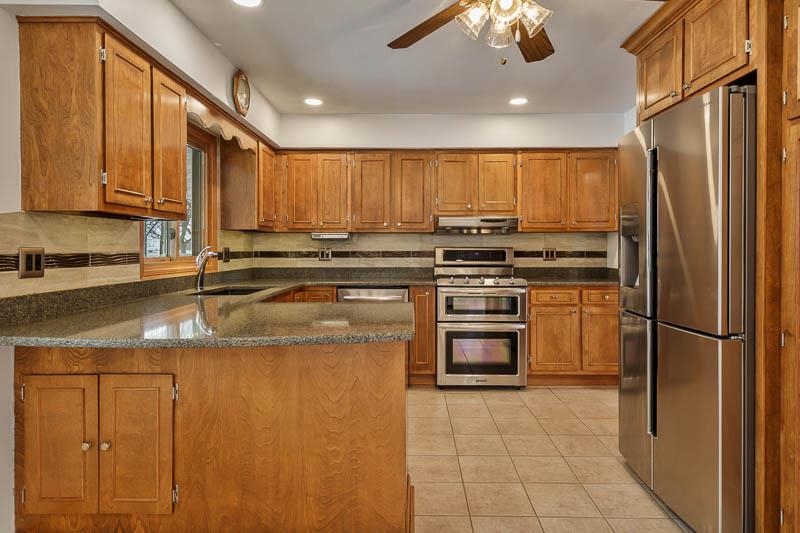 8611 Huber Road Belvidere, IL 61008 - Photo 40 of 79 a kitchen with stainless steel appliances granite countertop a refrigerator a stove and a sink with cabinets