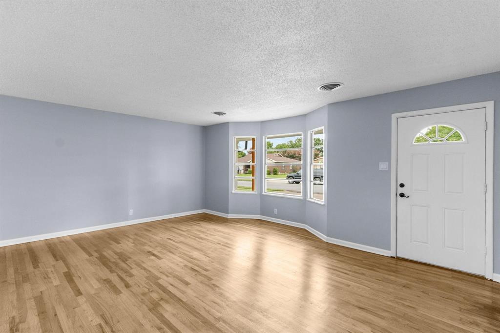 1818 Belden Street Sherman, TX 75092 - Photo 16 of 28 a view of an empty room with wooden floor and a window