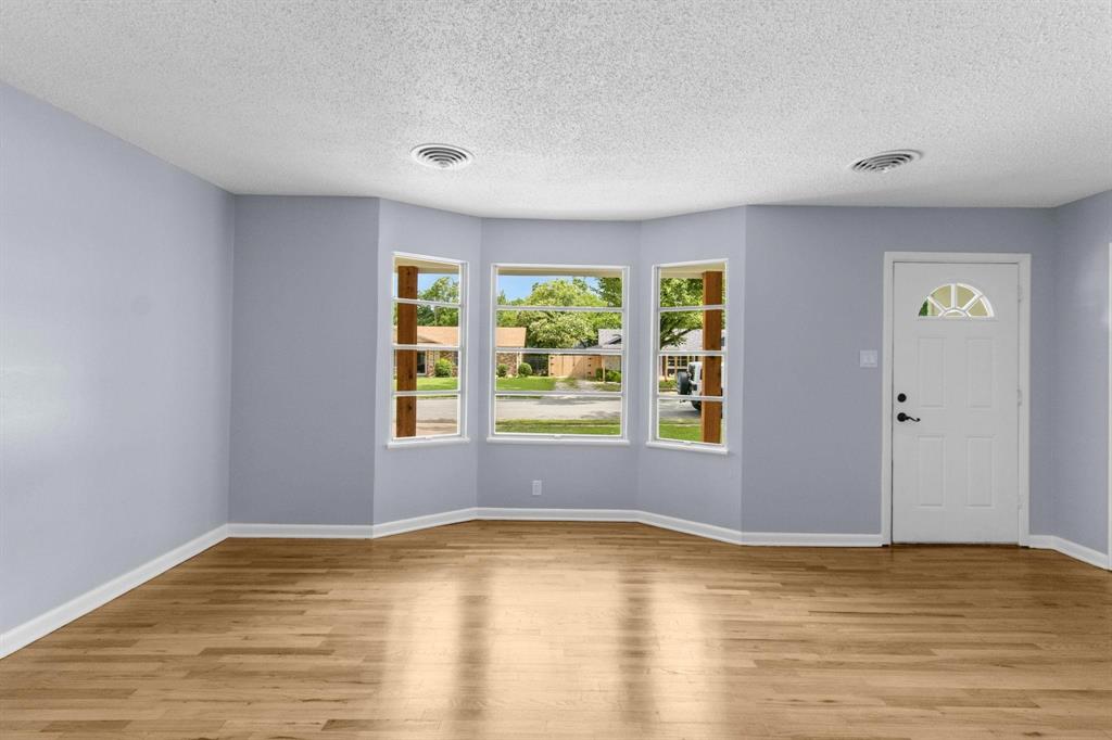 1818 Belden Street Sherman, TX 75092 - Photo 19 of 28 a view of an empty room with wooden floor and a window