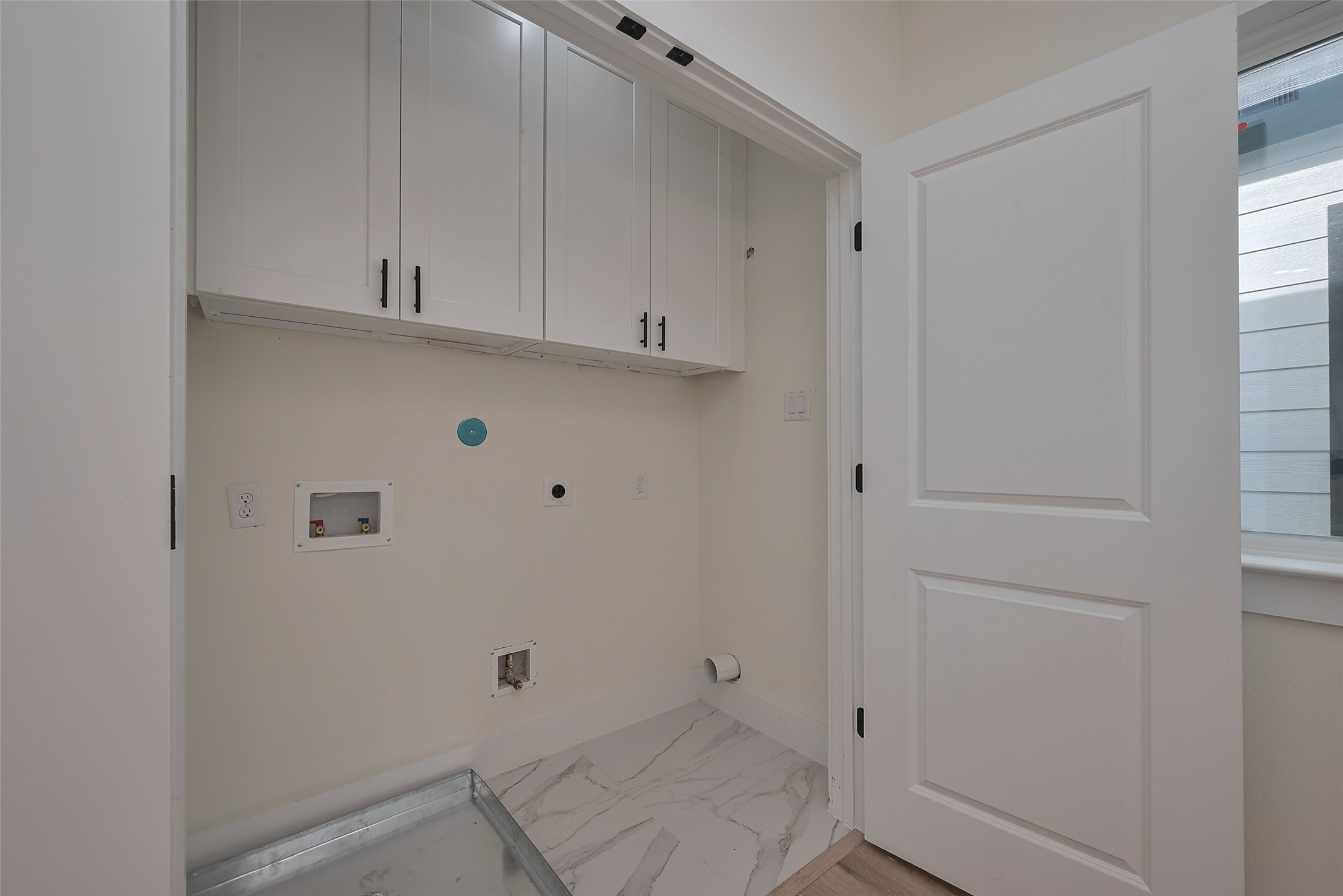 2422 Dalview Street Houston, TX 77091 - Photo 22 of 24 Hidden behind a sleek interior door is
the home’s dedicated laundry area,
featuring tall cabinets for practical
storage of cleaning supplies, linens,
and more.