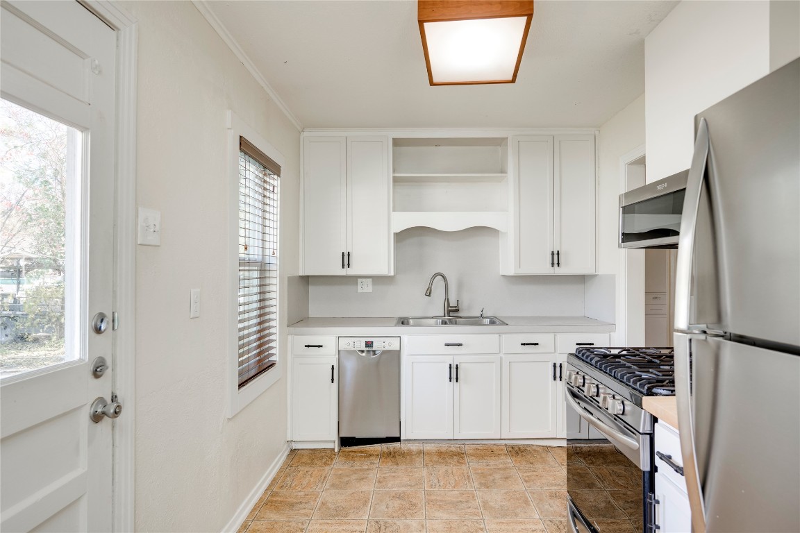 4804 Tanney Street Austin, TX 78721 - Photo 18 of 35 a kitchen with a stove a sink and a refrigerator