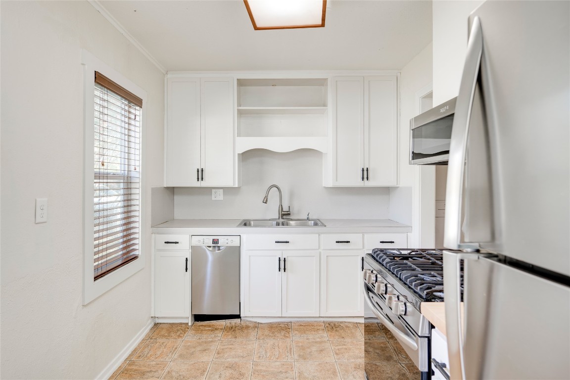 4804 Tanney Street Austin, TX 78721 - Photo 19 of 35 a kitchen with stainless steel appliances granite countertop a stove a sink and a refrigerator