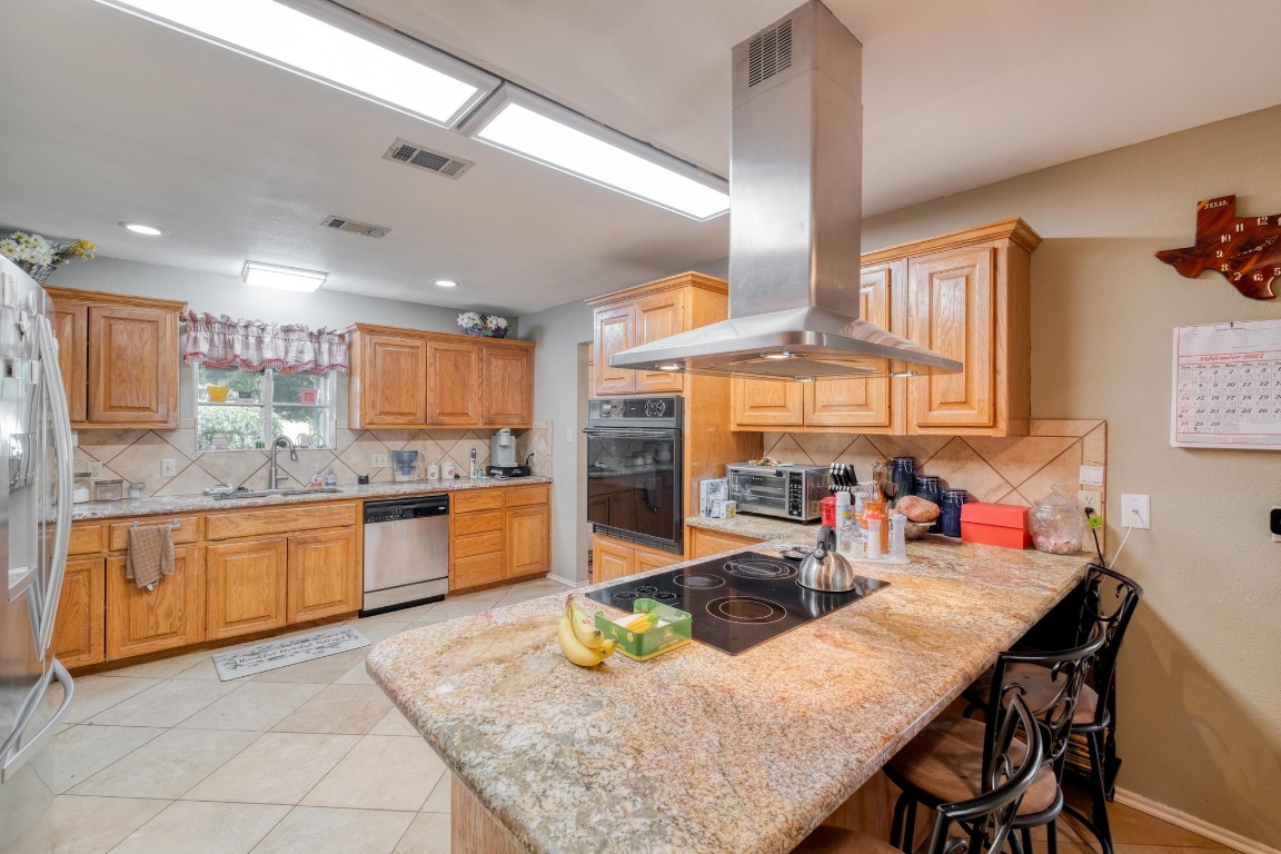 153 Pleasant Grove Road Elgin, TX 78621 - Photo 13 of 34 a kitchen with stainless steel appliances granite countertop a sink and cabinets