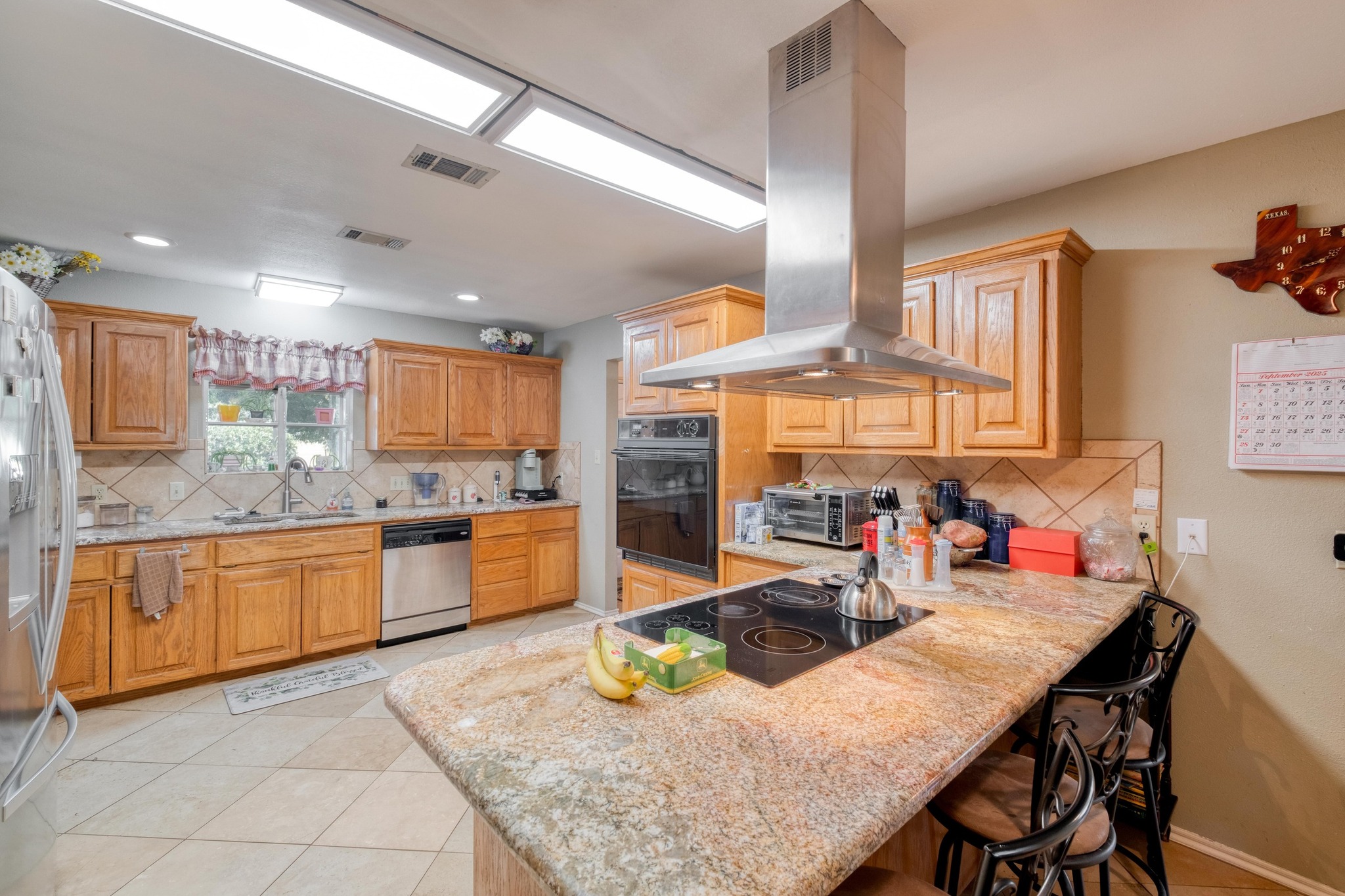 153 Pleasant Grove Road Elgin, TX 78621 - Photo 13 of 34 Kitchen with backsplash, light tile patterned floors, island range hood, light stone counters, and recessed lighting