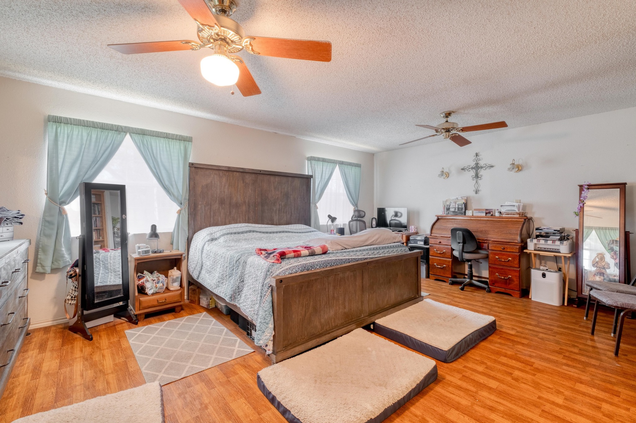 153 Pleasant Grove Road Elgin, TX 78621 - Photo 17 of 34 Bedroom featuring ceiling fan, a textured ceiling, light wood-style floors, and a desk